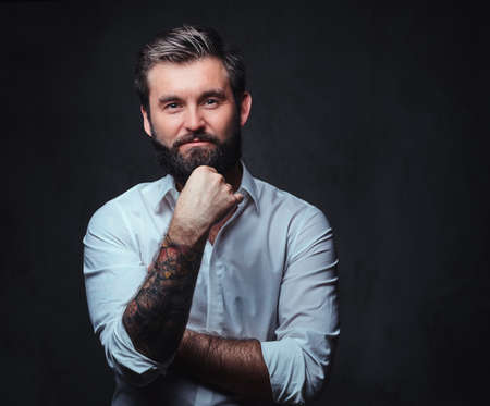 A man with tattoo on arm dressed in a shirt.の写真素材
