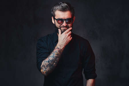 A man with tattoo on arm dressed in a shirt.の写真素材