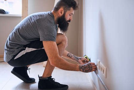 Carpenter measuring a wall.の写真素材