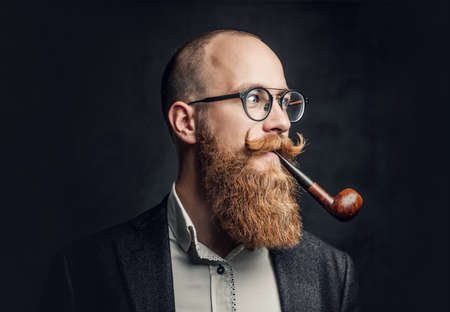 A man smoking pipe over grey background.の写真素材