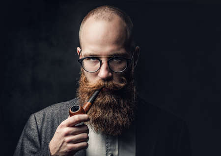 A man smoking pipe over grey background.の写真素材