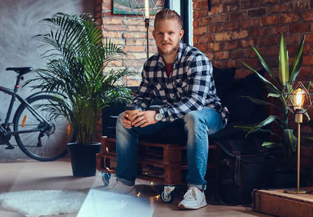 The full body image of blond hipster male drinks coffee.の写真素材