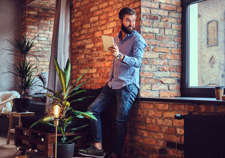 A man using tablet PC in a room.の写真素材