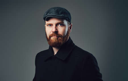 A man with redbeard over grey background.