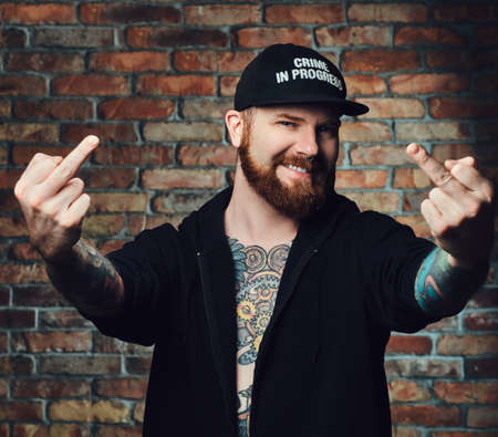 Tattooed bearded male over the wall of a brick.の写真素材
