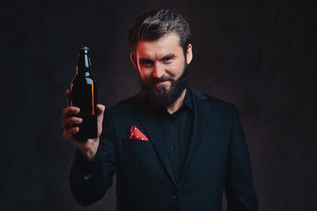 A man in a black suit presenting craft beer.の写真素材