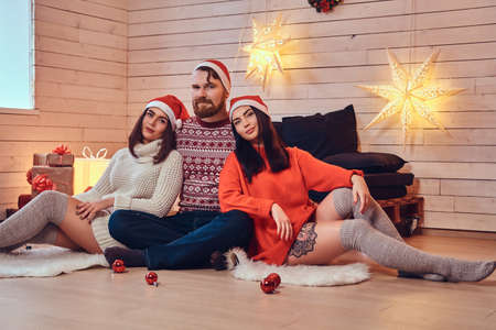 One bearded male and two brunette women Christmas party.