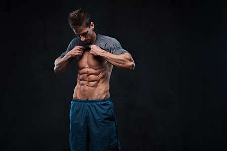 Shirtless muscular male over dark background.の写真素材