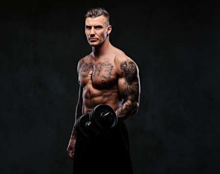 A muscular man doing exercises with dumbbells.の写真素材