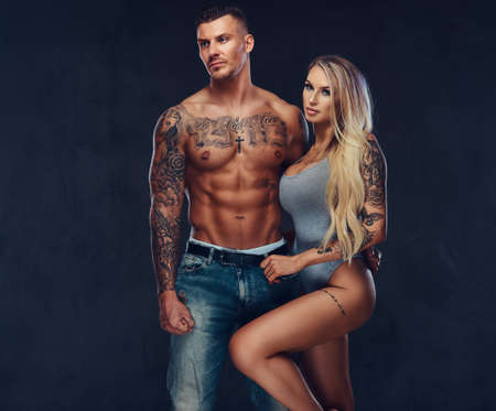 A sexy fit couple, posing on a dark blackground.の写真素材