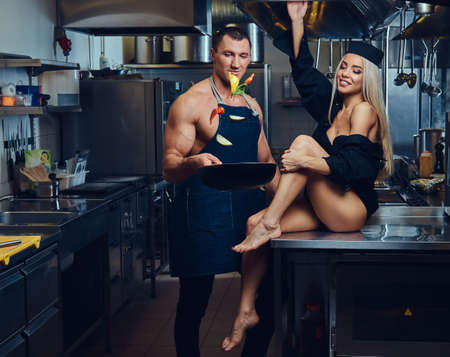 A sexy waitress flirts with an attractive cook.の写真素材