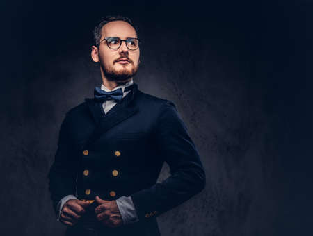Portrait of a bearded male in glasses and antique suit on a darkの写真素材