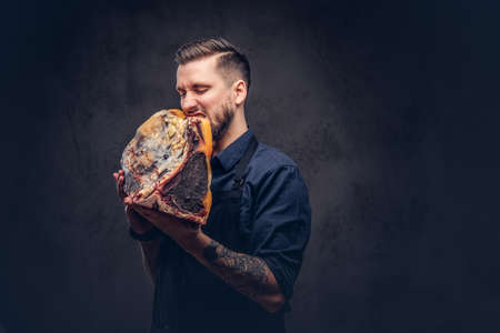 Professional butcher holds a big piece raw smoked meat.