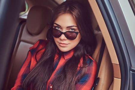 Portrait of a Caucasian woman in a flannel shirt and sunglasses