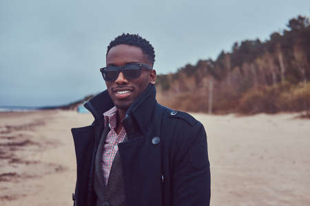 Close-up portrait of a handsome African-American guy on a beach.の写真素材