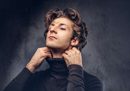 Portrait of a charismatic sensual male in black sweater.の写真素材