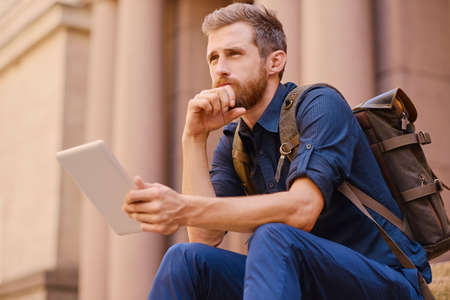 Handsome bearded male tourist in casual clothes and bagの写真素材