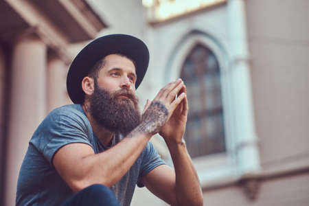 A handsome hipster male with a stylish beard with a tattoo on his armの写真素材