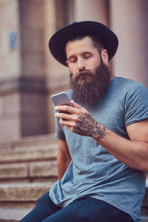 A handsome hipster male with a stylish beard with a tattoo on his armの写真素材
