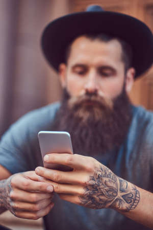 A handsome hipster male with a stylish beard and a tattoo on his armの写真素材