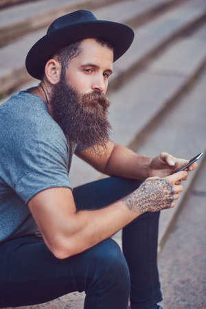A handsome hipster male with a stylish beard and a tattoo on his armの写真素材