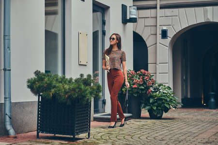 Beautiful fashionable brunette in a trendy clothing and sunglassesの写真素材