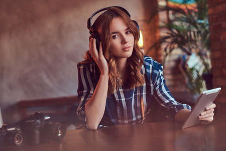 A young charming sensual girl listening to a music in headphones