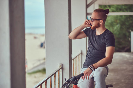 A handsome redhead male with a stylish haircut and beard dressed