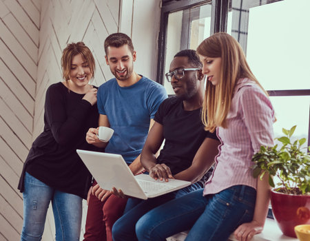 Group of multiracial students working with a laptop.