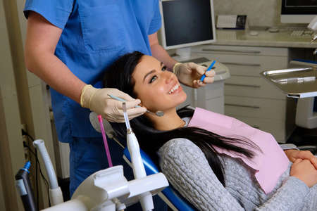 Beauty brunette having teeth examined at dentists.の写真素材