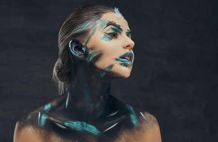 A young sensual girl with creative make-up. Blue and black shadows painted on her face. Conceptual...