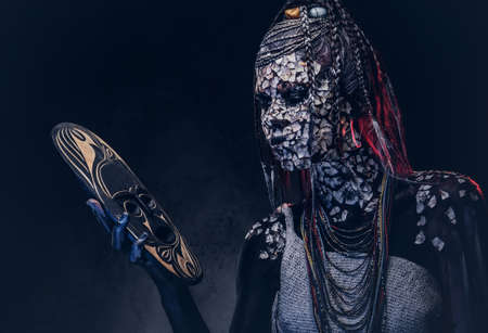 Make-up concept. Portrait of a scary African shaman female with a petrified cracked skin and...