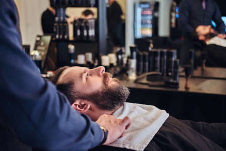 Master hairdresser prepares the face for shaving in the barber shop.の写真素材
