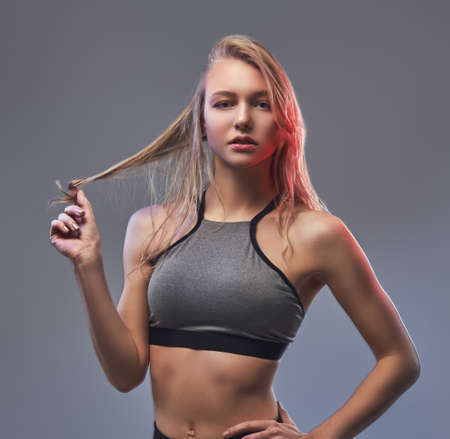 Sexy slim blonde girl in a sportswear posing in a studio.の写真素材