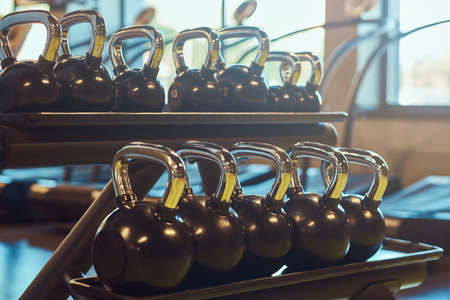 Weight training equipment in a modern gym indoors. Close-up image of dumbells on a stand. Gym...