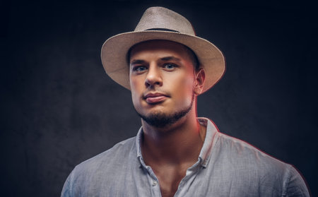 Close-up portrait of a handsome fashionable bearded man in a white shirt and panama hat.の写真素材