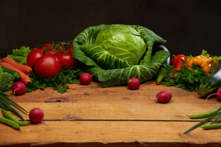 Fresh organic vegetables on a wooden boards background, top view.の写真素材