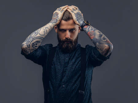 Portrait of a serious handsome old-fashioned hipster in shirt and suspenders.の写真素材