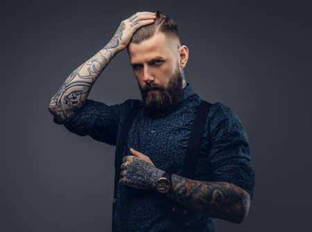 Portrait of a serious handsome old-fashioned hipster in shirt and suspenders.の写真素材