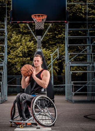 Portrait of a disabled basketball player in a wheelchair on an open gaming ground.の写真素材