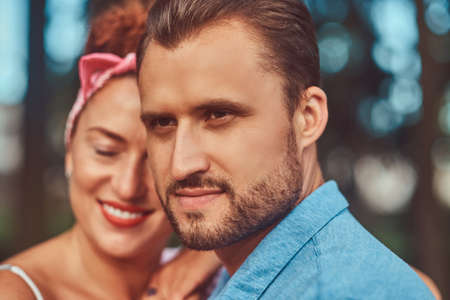 Close-up portrait of a happy attractive couple, cuddling during dating outdoors in a park.の写真素材