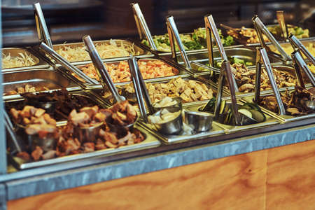 Close-up image of metal containers with different vegetables for fast food take away in a cafe.の写真素材