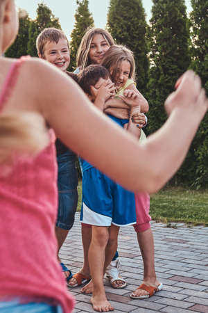 Group of happy little friends having fun at the yard.の写真素材