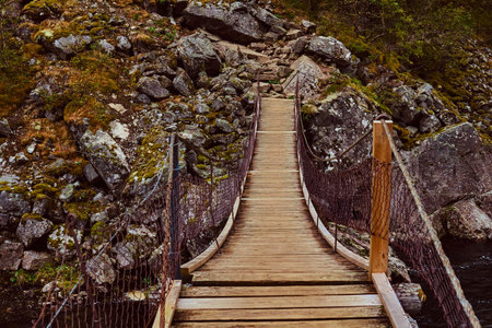 Narrow wooden bridge in mountains. Amazing nature in Norway.の写真素材