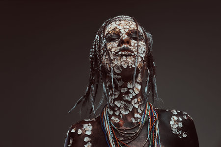 Portrait of a scary African shaman female with a petrified cracked skin and dreadlocks. Make-up concept.の写真素材