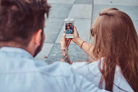 Close-up photo of a young happy couple makes selfie together outdoors.の写真素材