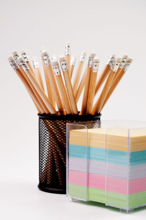 Group of pencils and note papers, isolated on a white background.
