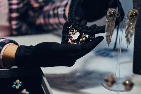 Close-up photo of a jewelry worker presenting a costly necklace with gemstones in a jewelry store.の写真素材