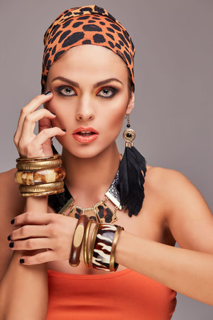 Beautiful caucasian woman with make-up wearing colorful shawl on head and accessories. Isolated on...