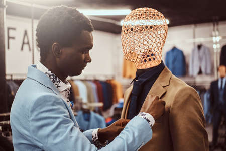 Elegantly dressed African-American man working at classic menswear store.の写真素材